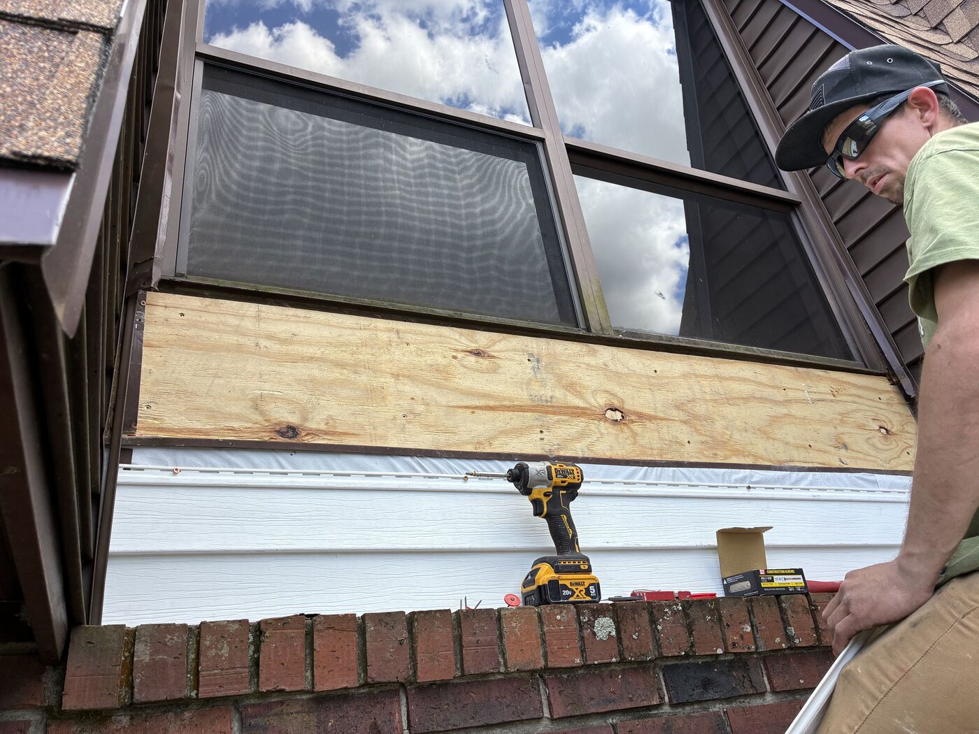 Siding replacement in progress under a window